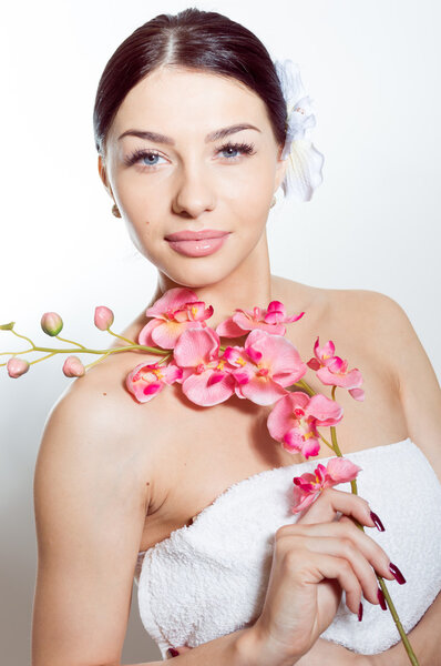 Beautiful woman holding a branch of orchid flowers