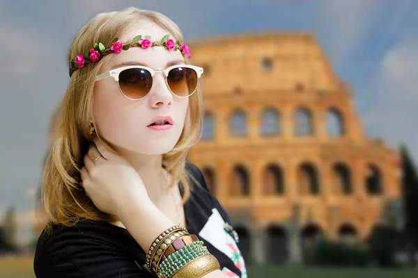 Pretty girl in sunglasses and wreath on Colosseum blurred background — Stock Photo, Image