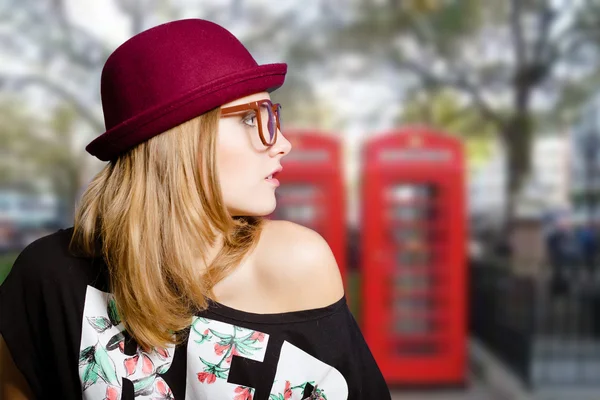 Charming girl in big glasses on London urban blurred background — Stock Photo, Image