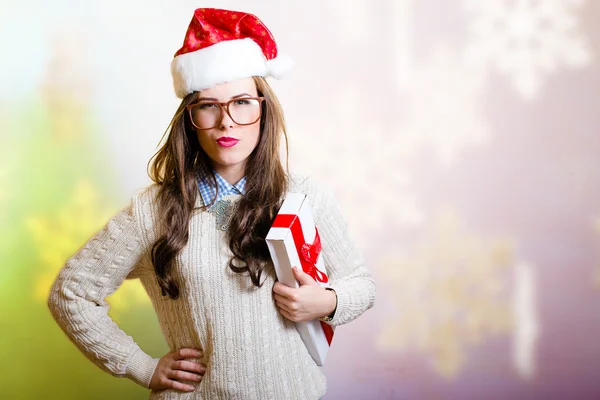 Young woman in Santa hat stressed on bright snowflake background — Stock Photo, Image