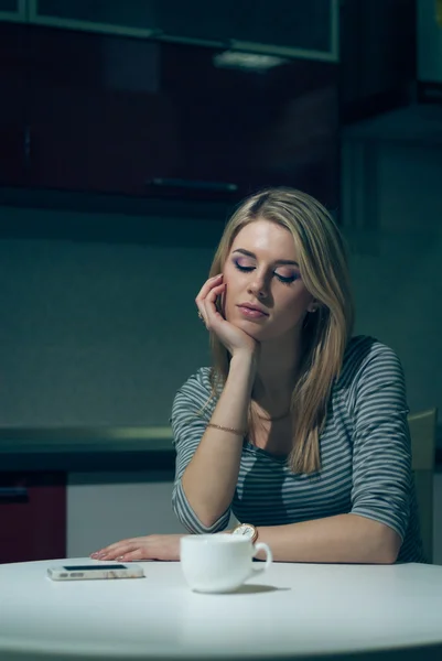 Jeune femme attend au téléphone sur une cuisine de nuit — Photo