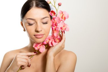 Bir dal orkide çiçek tutan güzel kadın