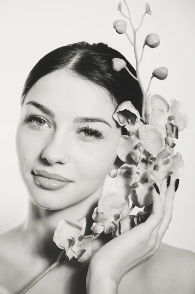 Mulher bonita segurando um ramo de flores de orquídea — Fotografia de Stock