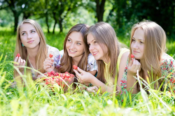 Vier jonge vrienden plezier aardbeien eten uit grote kom — Stockfoto