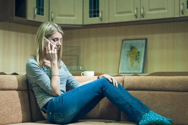 Mujer joven sentada sola y hablando por teléfono — Foto de Stock