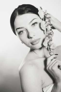 Bir dal orkide çiçek tutan güzel kadın