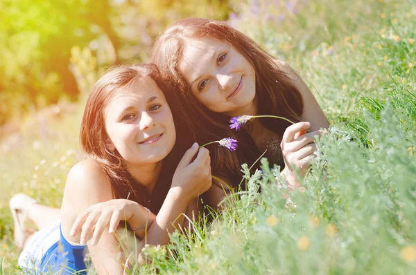 Duas amigas felizes brincando na grama verde — Fotografia de Stock