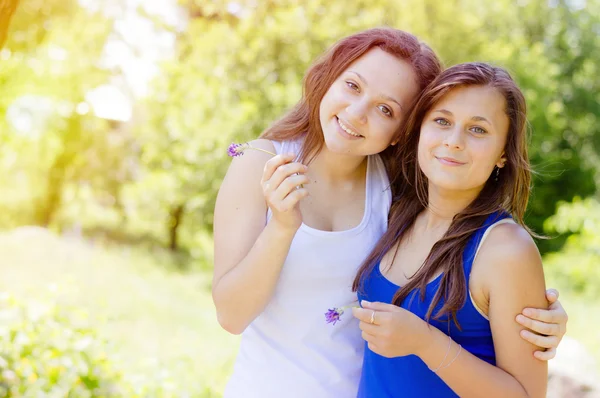 Two happy female friends hugging in green summer park — Stock Photo, Image