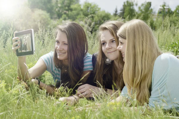 Tři šťastné mladé přítelkyně dělá selfie telefonicky — Stock fotografie