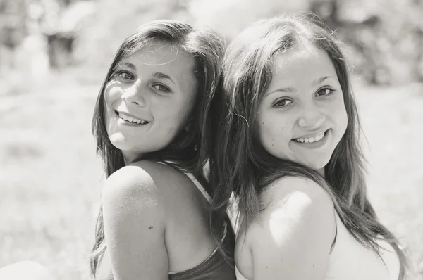 Dos amigas felices abrazándose en el verde parque de verano —  Fotos de Stock