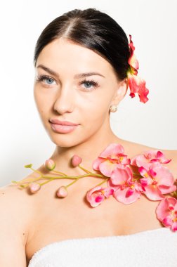 Bir dal orkide çiçek tutan güzel kadın