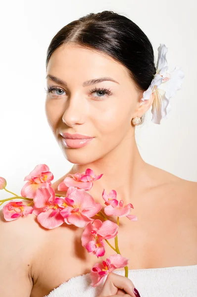 Mulher bonita segurando um ramo de flores de orquídea — Fotografia de Stock