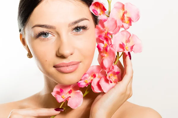 Beautiful woman holding a branch of orchid flowers — Stock Photo, Image