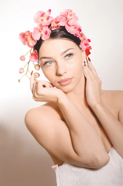 Beautiful woman holding a branch of orchid flowers — Stock Photo, Image