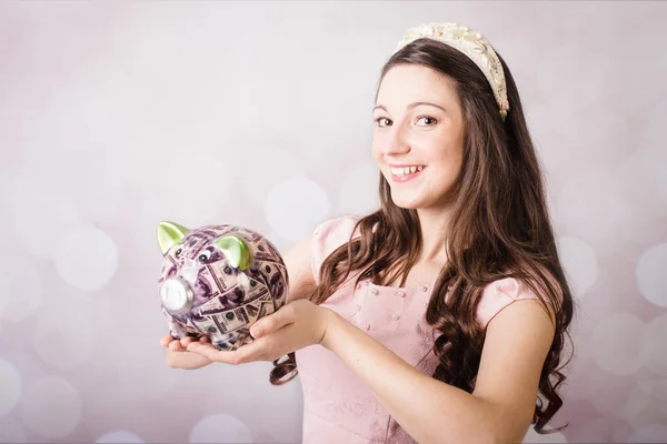 Beautiful young lady holding US banknotes and piggy bank — Stock Photo, Image