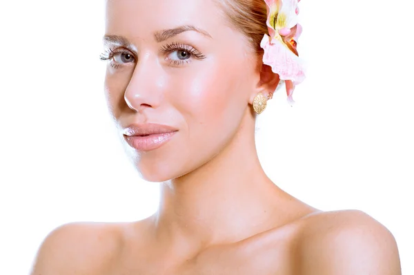 Krása tvář mladé krásné ženy s květinou — Stock fotografie