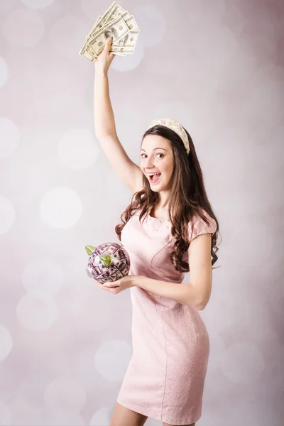 Menina bonita segurando notas dos EUA e banco porquinho — Fotografia de Stock