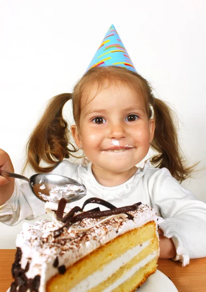 Zabawne dziecko dziewczynka kapelusz urodziny jedzenie ciasto — Zdjęcie stockowe