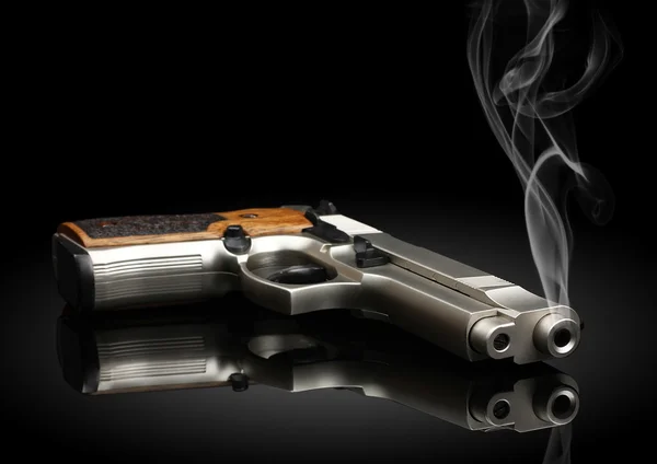 Pistolet na czarnym tle z dymu — Zdjęcie stockowe