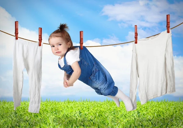 Funny child hanging on line with clothes, laundry creative conce — Stock Photo, Image