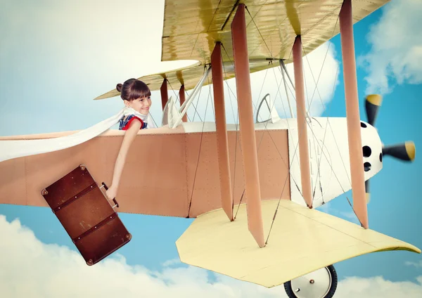 Girl with suitcase flying vintage plane. Photo in old image styl — Stock Photo, Image