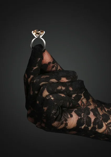 Mão luva segurar anel de jóias com gema, no fundo escuro — Fotografia de Stock
