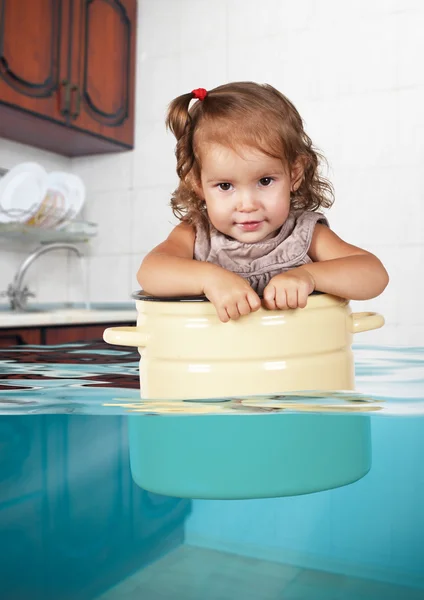 Funny little girl swim in pan in the flooded kitchen, rowdy crea — Stock Photo, Image
