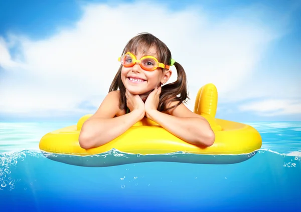 Funny little girl with diving glasses floating inflatable ring a — Stock Photo, Image