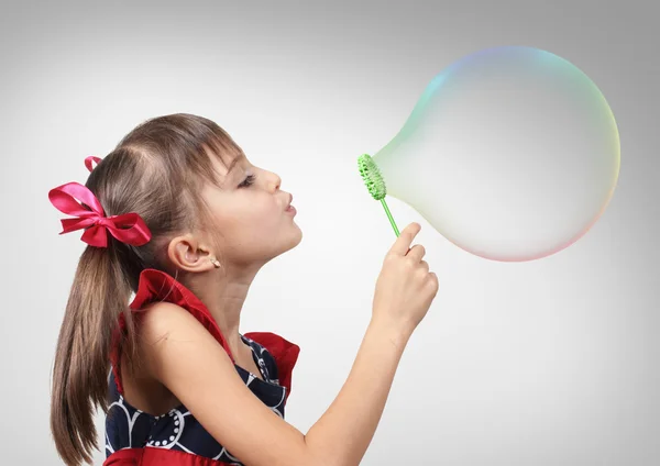 Portrait of funny child girl blowing big soap bubble, studio sho — Stock Photo, Image