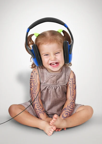 Funny niña con tatoo escuchar música con auriculares — Foto de Stock