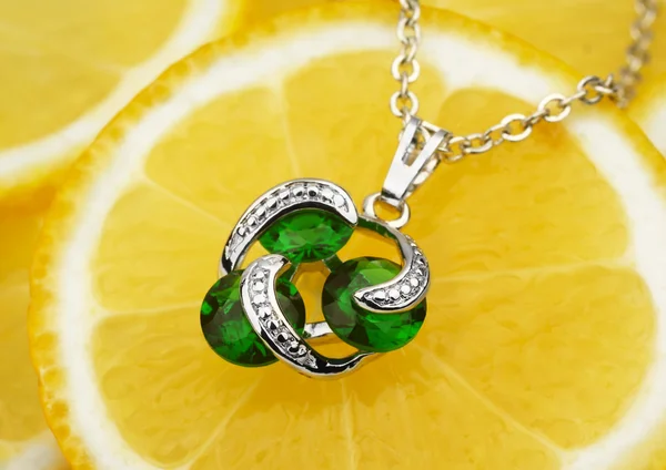 Farbenfroher Schmuckanhänger mit Edelsteinen und Diamanten auf Zitronenrücken — Stockfoto