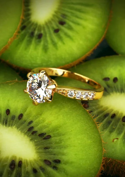 Bague bijoux avec gros diamant sur fond de kiwi fruit, verticale — Photo