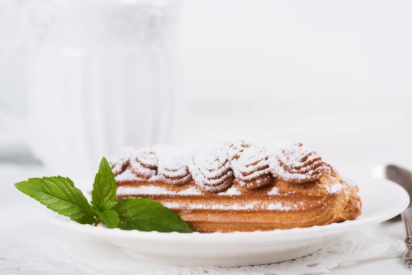 Eclairs em chapa em uma mesa — Fotografia de Stock