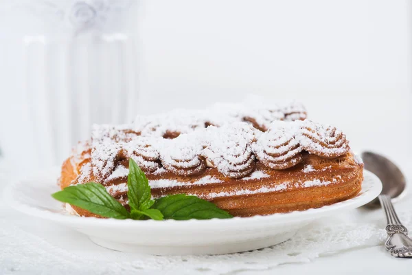 Eclairs em chapa em uma mesa — Fotografia de Stock