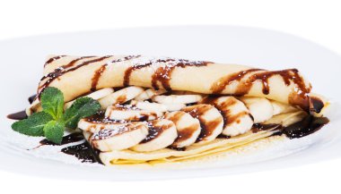 Muz doldurulmuş krep ve çikolata bir plaka üzerinde