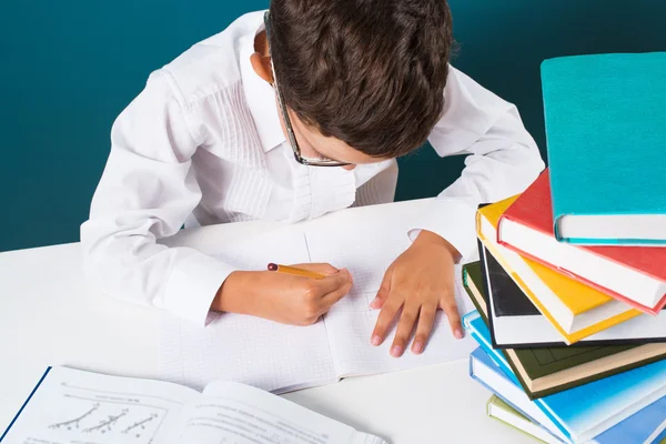 Fundersam söt pojke med läxor som sitter — Stockfoto