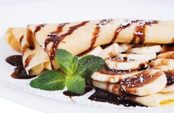 Panqueques rellenos de plátanos y chocolate en un plato — Foto de Stock