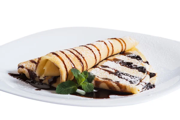 Pancakes with chocolate sauce and mint  on a plate — Stock Photo, Image