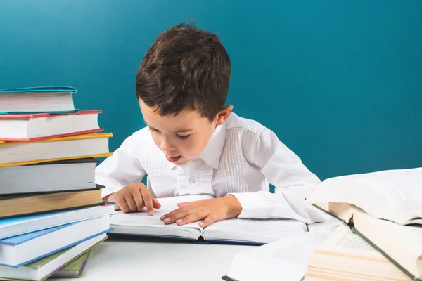 Netter Junge liest Buch am Tisch — Stockfoto