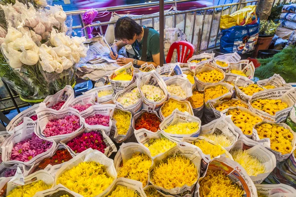 Man verkoopt kleurrijke bloemen op de flowermarket in Bangkok vroeg — Stockfoto