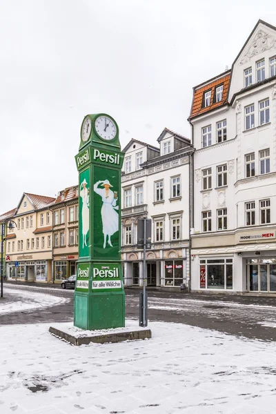 Old clocktower with advertising for washing powder in snow — Stock Photo, Image