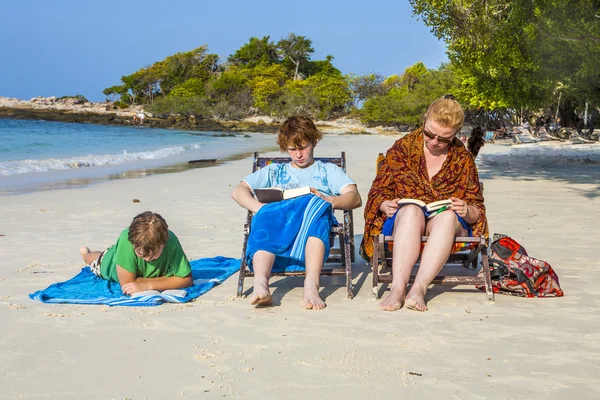 Familia está disfrutando del sol y relajándose y leyendo libros en el — Foto de Stock