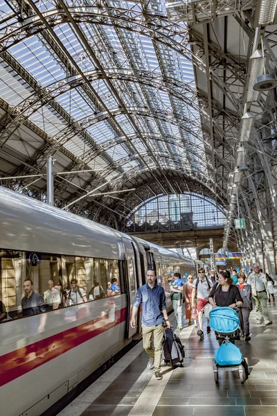 I viaggiatori a piedi intorno alla piattaforma ferroviaria nella sala centrale di — Foto Stock