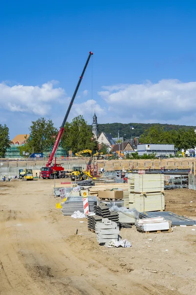 Werknemers helpen de uitvoering van bouwmateriaal aan de const kraan — Stockfoto