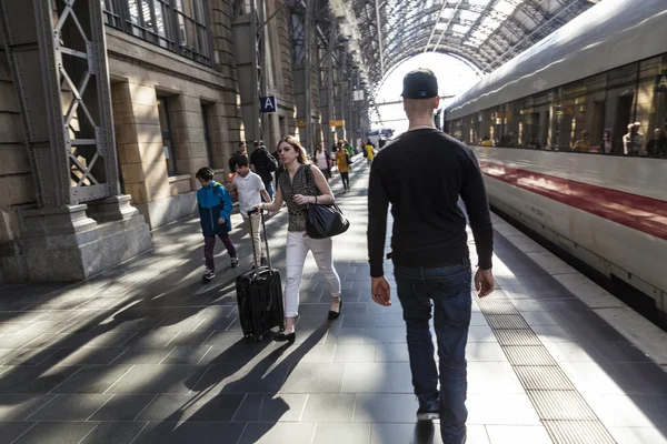 Путешественники ходят по железнодорожной платформе в центральном зале — стоковое фото