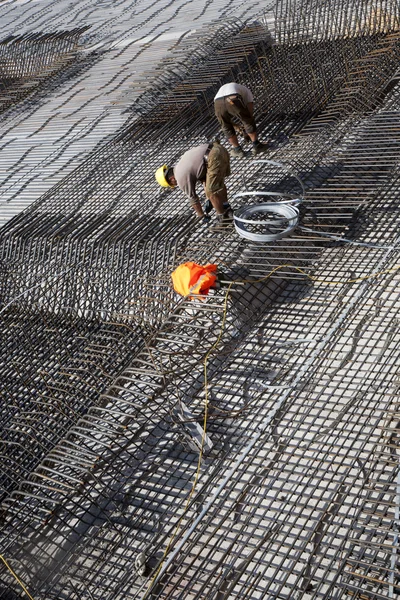 İşçiler binanın temeli için demir çubuklar inşa ederler. — Stok fotoğraf