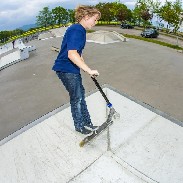 Young boy going airborne with scooter — Stock Photo, Image