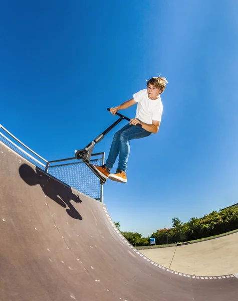 Junge springt mit seinem Roller — Stockfoto