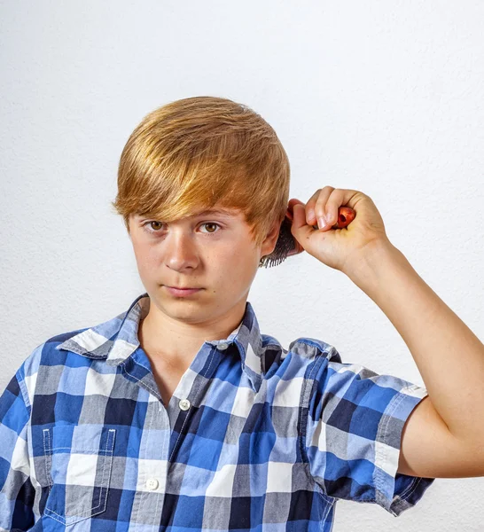 Giovane ragazzo spazzolando i capelli — Foto Stock