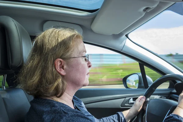 Mujer conduce el coche concentrado en una carretera alemana — Foto de Stock